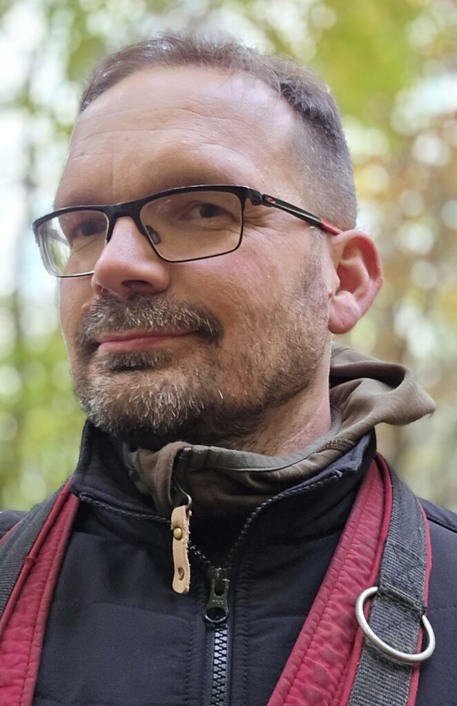 Mensch mit Brille und einem Lächeln